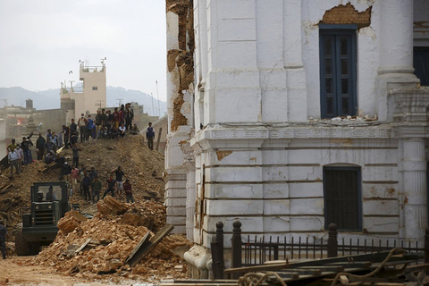 People work to rescue trapped people inside a temple in Bashantapur Durbar Square after an earthquake hit