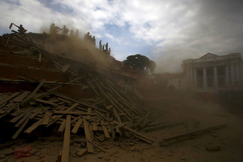 People work to rescue trapped people inside a temple in Bashantapur Durbar Square after an earthquake hit