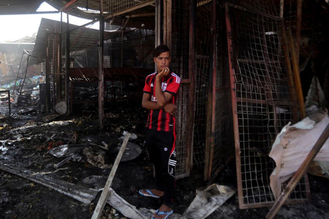 An Iraqi man stands amid the debris in the aftermath of a massive suicide car bomb attack carried out by the Islamic State group in the predominantly Shiite town of Khan Bani Saad