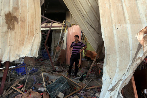 An Iraqi man stands amid the debris in the aftermath of a massive suicide car bomb attack carried out by the Islamic State group in the predominantly Shiite town of Khan Bani Saad