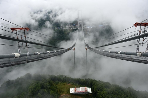 2015年7月31日，云南保山，亚洲最大的山区在建跨径钢箱梁悬索桥——龙江特大桥第一节钢箱梁在腾冲塔岸吊装成功，标志着大桥全面转入项目建设重要关键工序的施工，预计明年6月通车。 李文圣/CFP
