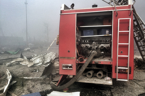 2015年8月13日，天津滨海新区爆炸事故点东侧的跃进路上，五辆消防车受损严重损毁，车内已无消防员，消防装备散落周围。跃进路上还停放着大量被炸毁的大货车，部分车辆仍处于点火状态。 潘之望/东方IC 