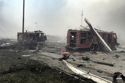 2015年8月13日，天津滨海新区爆炸事故点东侧的跃进路上，五辆消防车受损严重损毁，车内已无消防员，消防装备散落周围。跃进路上还停放着大量被炸毁的大货车，部分车辆仍处于点火状态。 潘之望/东方IC 