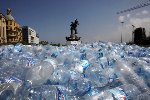 在市中心的烈士广场雕塑下,堆放了等待回收的塑料水瓶.