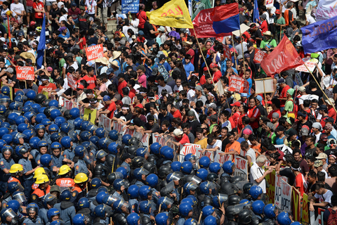 当地时间2015年11月19日，菲律宾马尼拉，菲律宾警方与反对者在街头对峙。18日至19日，亚太经合组织第二十三次领导人非正式会议在菲律宾马尼拉举行，菲律宾多地针对APEC峰会举行抗议示威活动，并与防暴警察发生冲突。 PUNIT RANJPE/视觉中国