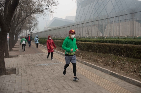 2015年12月8日，北京，东三环，一名路人在街边慢跑。雾霾天气里，选择在户外锻炼的人很少。 韦毅/财新视觉中心实习生