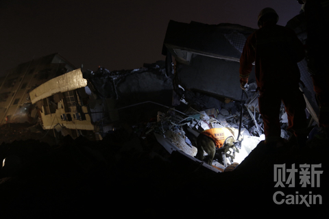20时许，救援人员连夜救援。这堆泥土下面埋着大约三四间厂房，泥土约有三层楼高，两辆挖掘机正在挖开泥土搜寻生还者。 梁莹菲/财新记者