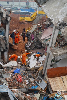 2015年12月21日，广东深圳，光明新区山体滑坡事故现场，搜救犬正在寻找生还者。 梁莹菲/财新记者