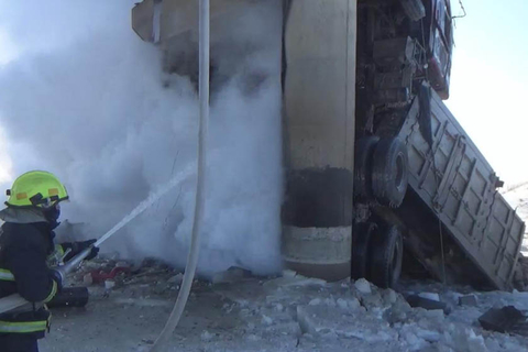 两辆大货车坠桥掉落在冰面上起火，消防员在现场灭火。 海军/视觉中国 