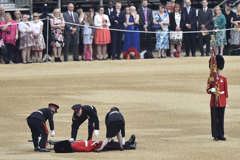 几名英国警员在将晕倒的卫兵抬上担架. 东方ic