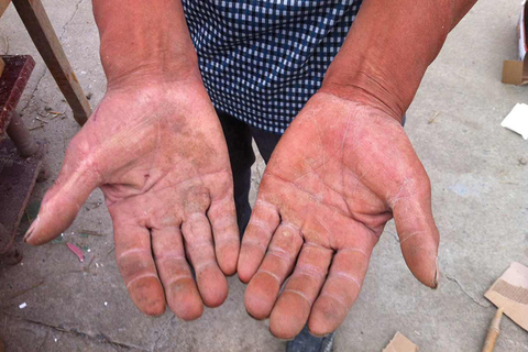 村民陈斯州展示他的沾着泥巴和长着茧的双手，他徒手从废墟中挖出4人。 萧辉/财新记者