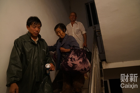 湖北省武汉市蔡甸区消泗乡，工作人员在排查尚未离开的村民，有老人家因收拾东西、行动不便等原因迟迟不能离开。 图/财新记者 梁莹菲