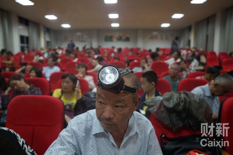 湖北省武汉市蔡甸区消泗乡，汉南中学安置点，怕看不清路而戴着探照灯的老伯。 图/财新记者 梁莹菲