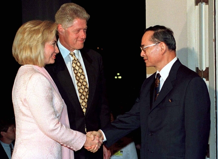 Thai King Bhumibol Adulyadej shakes hands with U.S. First Lady Hillary Rodham Clinton as President Bill Clinton looks on during their meeting at Chitrlada Palace in Bangkok November 25. Clinton is in Thailand for a one day state visit