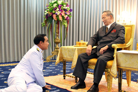 epa04501781 A Royal Household Bureau handout photo made available on 24 November 2014 shows Thai King Bhumibol Adulyadej (R) talks to Prime Minister Prayut Chan-o-cha (L) during the two new deputy ministers sworn in ceremony at Siriraj Hospital in Bangkok