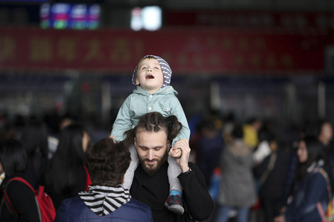 镜头捕捉“袋鼠爸妈” 带娃挤春运你准备好了吗