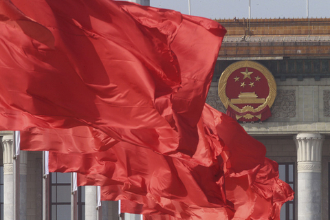 2017年3月2日,在北京天安门广场,刚刚悬挂的红旗与人民大会堂的国徽遥