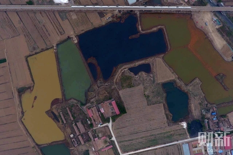 2017年4月19日，天津市静海区西翟庄镇佟家庄村以东，高铁铁轨正下方西侧农田内有6个污水渗坑，总面积约15万平方米。污水渗坑均为明显异色，如几个巨大的彩色补丁拼接在一起。 图/财新记者 陈玮曦