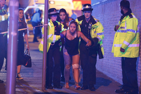 据英国媒体报道,英国曼彻斯特竞技场（Manchester Arena）于当地时间5月22日晚发生爆炸。截至北京时间5月23日8时30左右，据新华社报道，英国警方证实，爆炸已造成19人死亡、约50人受伤。据悉，事发时，美国歌手爱莉安娜·格兰德(Ariana Grande)正在该体育场举行演唱会。图为爆炸发生后，警察在曼彻斯特竞技场（Manchester Arena）附近帮助受伤者。图/东方IC