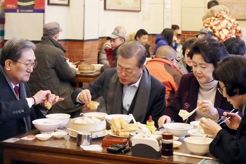 2017年12月14日，北京，正在中国访问的韩国总统文在寅及夫人金正淑在韩国驻华大使卢英敏的陪同下品尝中式早餐，与民众一起用早餐，点了油条、豆浆以及小笼包。图/视觉中国