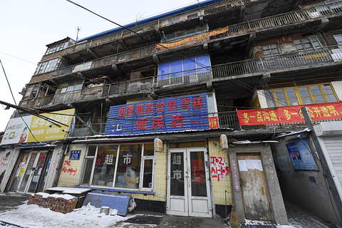 2018年1月12日，在吉林省长春市二道区荣光路附近，一座破旧的楼房屹立在马路一侧，面对街道的一侧破烂不堪，整栋楼有数十个房间，每个房间的外观均不相同，颜色各异，整个楼体就像修补过一样，满目疮痍。图/视觉中国