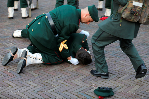 当地时间2018年3月21日，荷兰海牙，荷兰国王威廉-亚历山大和法国总统马克龙检阅皇家卫队时，一名皇家卫兵晕倒。图/视觉中国