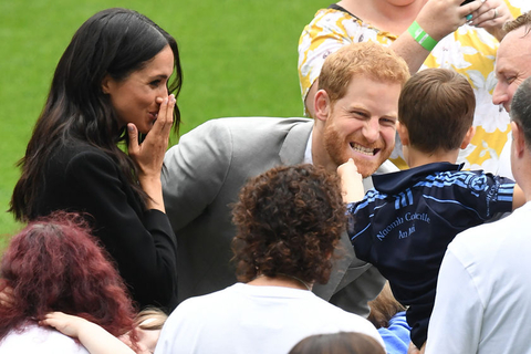 2018年7月11日，爱尔兰都柏林，哈里王子和梅根王妃出访爱尔兰，在克罗克体育场参观访问。哈里王子的大胡子遭顽皮的小孩伸手抚摸，一旁的梅根也被逗笑。图/视觉中国