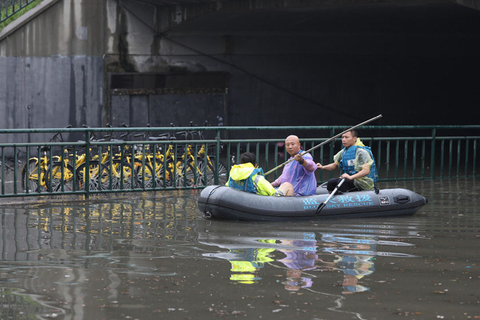 2018年7月16日上午，受北京暴雨影响，昌平回龙观地区的很多路口、路段出现不同程度积水，其中对交通造成严重影响的是回龙观城铁桥下，因积水已经造成交通中断。桥下多车被淹没，救援人员坐皮划艇靠近实施救援。图/东方IC