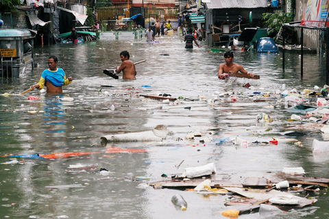 当地时间2018年7月17日，菲律宾马尼拉，季风雨和热带风暴导致当地发生洪灾。一些低洼地区积水成灾，不少塑料品和可再循环物品随水漂流，一些居民正收集塑料瓶和其他可循环再利用的物品。图/视觉中国