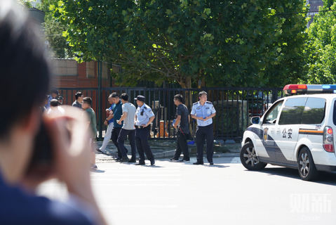 2018年7月26日，爆炸点附近执勤巡逻的工作人员。下午1时许，北京，美国驻华大使馆东门附近发生爆炸，爆炸发生后武警、警察赶到现场。图/财新记者 夏伟聪