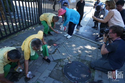 2018年7月26日，爆炸点附近，工作人员清理爆炸后地面的残留物。 图/财新见习记者 李坤