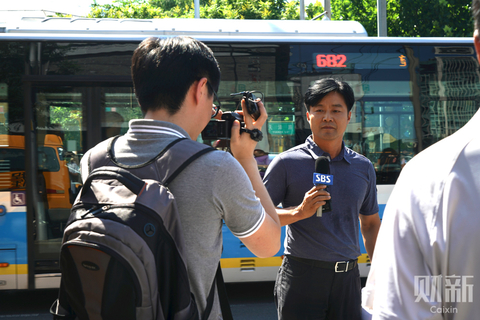          2018年7月26日，媒体记者在爆炸现场附近进行播报。 图/财新见习记者 蔡颖莉