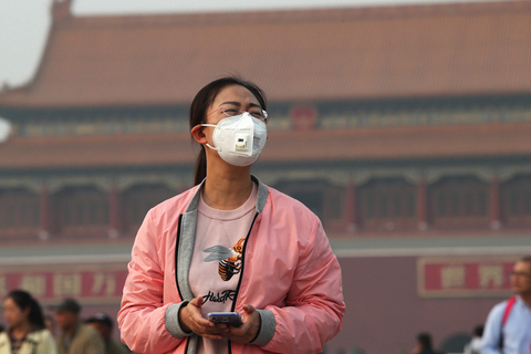 2018年10月14日，北京，游客戴着口罩游览天安门广场。北京环保监测中心预报，15日白天，北京部分地区部分时段将达到重度污染水平，预计将到达此次污染过程的峰值。15日入夜后，高空降温明显，污染浓度有所降低；16日地面为北部高压控制，预计空气质量良-轻度污染，本次污染过程结束。不过，雾霾被短暂吹散后，19日至21日，京津冀区域中部大气扩散条件再度较差。图/东方IC