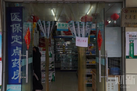 2020年1月22日，湖北武汉，华南海鲜市场边的一家药店，店门前贴纸“口罩已售罄”。图/财新记者 丁刚