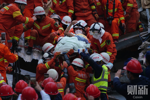 2020年3月10日，福建泉州欣佳酒店楼体坍塌事故现场，一名受困近70小时的幸存者被救援人员用担架抬出，举起手臂回应众人的欢呼声。