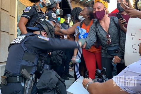 美东时间2020年5月31日，美国华盛顿，抗议者集中在白宫附近。城市中可以看到前一晚暴力留下的痕迹，在城市的一角，有警察与抗议者跪地握手。图/财新记者 张琪