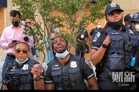 美东时间2020年5月31日，美国华盛顿，当地警察和抗议者们开展街头对话。不同族裔的警察们和抗议者之间的问答交锋，显现出示威议题之复杂和种族藩篱的疤痕之深。图/财新记者 张琪