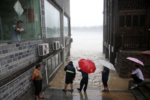 2020年6月28日，重庆市黔江区濯水古镇干部群众在观察洪水的涨势。6月27日4时至28日11时，重庆市黔江区遭遇今年以来最强降雨，34个雨量站超过100mm，最大降雨量为217.4mm。图/人民视觉