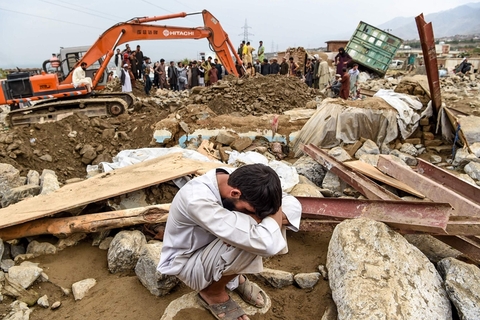 当地时间2020年8月26日，阿富汗东部帕尔万省恰里卡尔，一名男子在被摧毁的房屋旁，救援人员正在搜寻幸存者。阿富汗国家灾害管理部27日发表声明说，自25日夜间起，阿东部12个省遭遇洪水灾害，目前已造成122人死亡，147人受伤。阿国家灾害管理部的数据显示，洪水造成东部12个省份近1500栋房屋和1100多公顷农田被毁。图/人民视觉