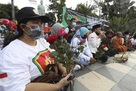 当地时间2021年4月25日，印度尼西亚东爪哇泗水，当地民众和僧侣为遇难船员祈祷。图/人民视觉