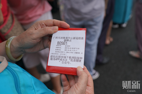 2021年5月26日，广州天河体育中心新冠疫苗大型临时接种点，市民手持号牌等待接种。 图/财新记者 梁莹菲