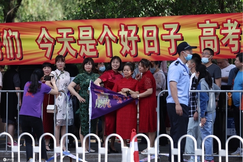 2021年6月7日，辽宁沈阳，高考第一天，学生们进去考场，家长身穿旗袍助威加油，寓意学生旗开得胜。图/IC photo