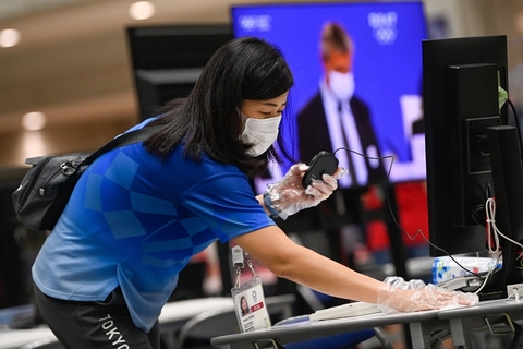 当地时间2021年7月20日，日本东京，2020东京奥运会前瞻，志愿者对媒体中心工作台进行消毒。图/IC PHOTO