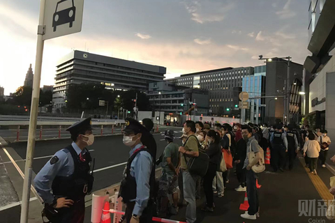 在东京奥运会开幕前的最后一个小时──日本时间7月23日晚间7时许，在接近东京奥运会主会场国立竞技场周边的JR信浓站附近，不少群众带着口罩站在路旁，准备迎接奥运会的开幕。但在东京街头，傍晚晚高峰的人流明显比寻常日子要少，大多数民众可能选择回到家里收看电视转播。奥运会开幕当晚，东京气温仍有摄氏29度，显得有些闷热。国立竞技馆附近也出现不少负责维安的员警，保证活动的安全。图/驻东京记者 陈立雄