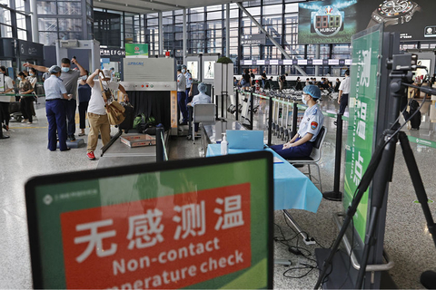 2021年8月1日，上海，在虹桥机场T2航站楼，工作人员对旅客进行无感测温。据悉，上海浦东和虹桥两机场加强疫情防控工作，对所有国内到达旅客在体温检测的基础上进行健康码查验，机场方面将根据查验结果予以放行或根据防疫政策安排后续处置。同时，现场设有健康状况申报台，供旅客主动申报。图/殷立勤/中新社
