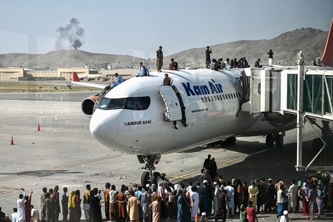 当地时间2021年8月16日，阿富汗喀布尔，大批阿富汗人围堵喀布尔机场，并爬上在喀布尔机场等待的飞机。据阿富汗媒体报道，3名民众挂在飞机起落架上试图逃离喀布尔，却不幸从空中跌落。图/人民视觉
