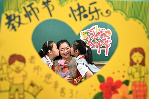 2021年9月10日，第37个教师节，各地展开多样庆祝活动。河北省邯郸市丛台区曙光小学的学生将制作的手工艺品送给老师并亲吻老师。图/视觉中国