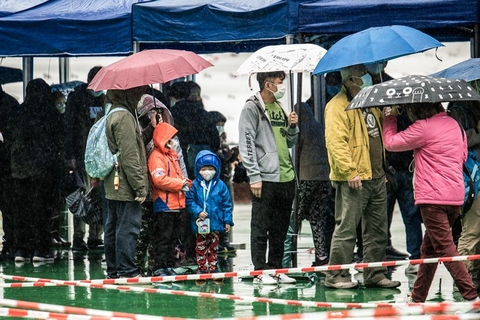 2022年2月20日，中国香港，当天是香港这个冬天最冷的一天，但在社区检测中心，仍有大批市民在寒冷的风雨中撑伞排队等候。据香港特区政府卫生署卫生防护中心20日公布，截至当天零点，香港新增6067例新冠肺炎确诊病例，其中6055例属本地感染。图/IC photo