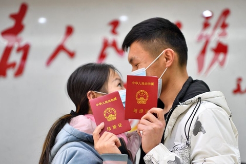 2022年2月22日，在湖北省襄阳市保康县民政局婚姻登记处，一对新人在领取结婚证后合影留念。结婚是人生大事，很多人都会精挑细选结婚的日子。因“2”与“爱”谐音，2022年2月22日星期二，这个拥有多个“2”的日子，成为新人领证结婚的热门日期。图/视觉中国